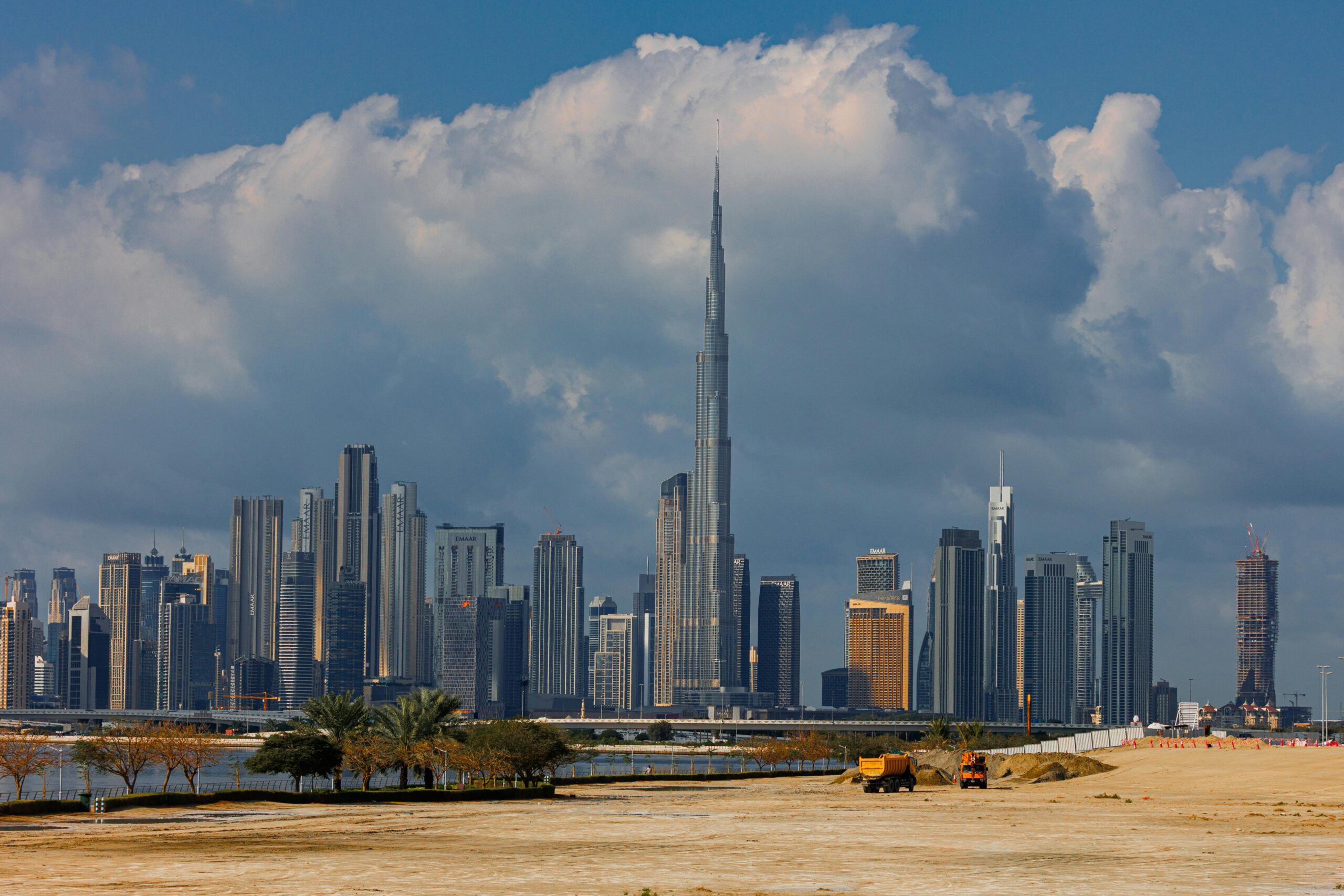 About A breathtaking view of the Burj Khalifa towering over the stunning skyline of Dubai under dramatic clouds.